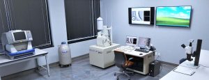 Scanning Electron Microscope room with large TVs for data presentation.